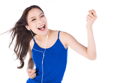 Smiling young woman standing against white background