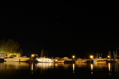 Illuminated lake against clear sky at night