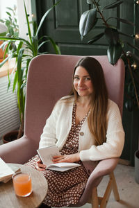 Millennial woman reading a book sitting in chair in cafe. candid lifestyle in cafe 