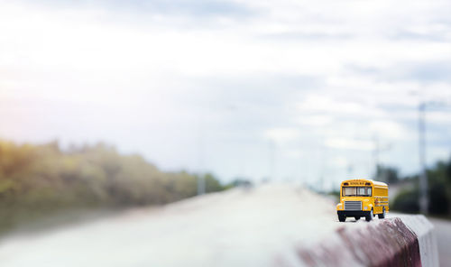 Yellow car on road against sky