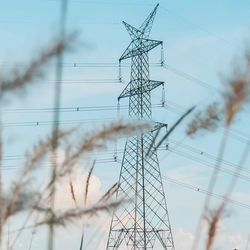 Low angle view of electricity pylon against sky