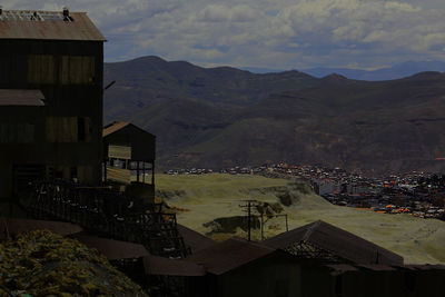 Townscape by mountains against sky