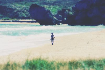 Rear view of a woman walking on beach