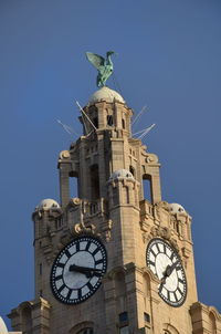 Low angle view of clock tower against building