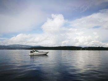 Boat sailing on lake against sky