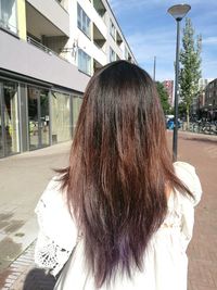 Rear view of woman standing on city street