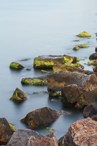 Scenic view of rocks in sea against sky