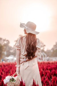 Side view of young woman with flowers
