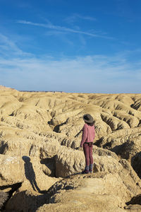 Rear view of woman standing on rock