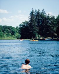 Man swimming in pool by lake against sky
