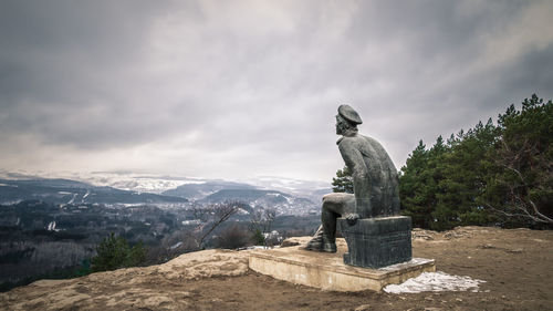 Statue by mountain against sky