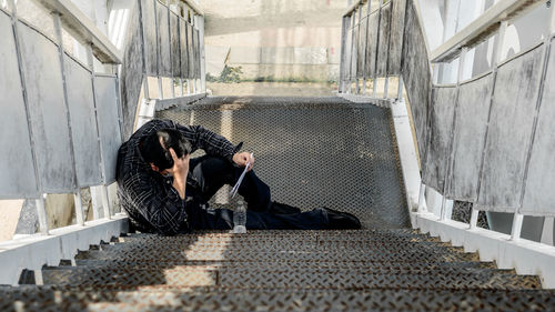 High angle view of man sitting on staircase in building