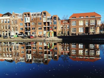 Reflection of buildings in canal against sky
