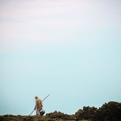 Man walking by plants against clear sky