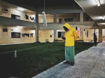 Rear view of woman standing in illuminated room