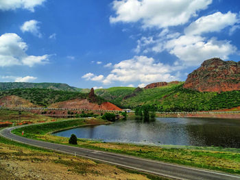 Scenic view of pond by mountains against sky