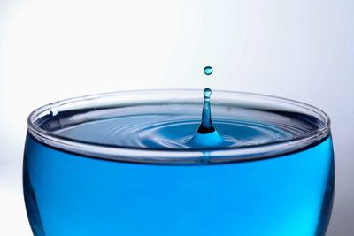 Close-up of blue glass against white background