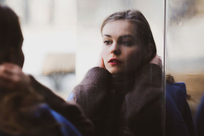 Young woman looking in window