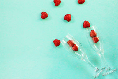 High angle view of red berries against blue background