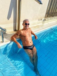 Full length of shirtless man in swimming pool