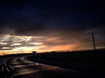 Silhouette of road against sky at sunset