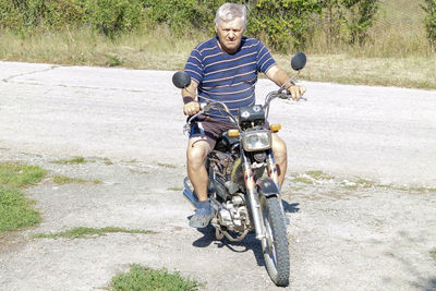 Full length of man riding bicycle on road