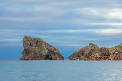 Rock formation in sea against sky