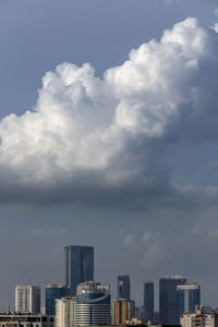 Buildings in city against cloudy sky