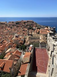 High angle view of townscape by sea against clear sky