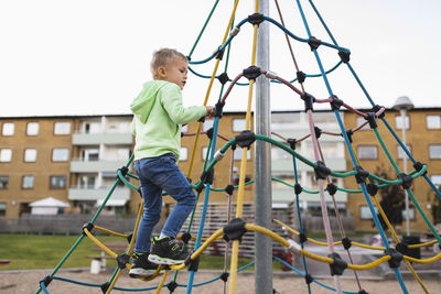 Boy climbing rope in park