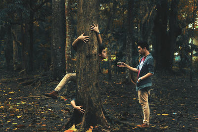 Digital composite of man gesturing towards himself embracing tree