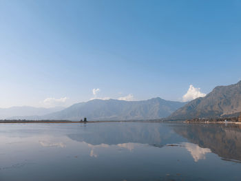 Scenic view of lake and mountains against blue sky