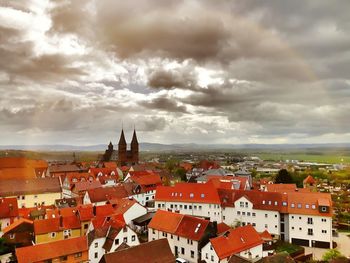 Crowd in city against cloudy sky