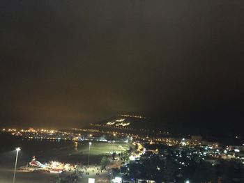 Illuminated cityscape against sky at night