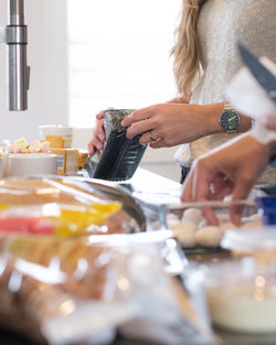 Midsection of woman having food at home