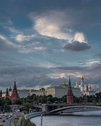 Spasskaya tower by moscva river against cloudy sky
