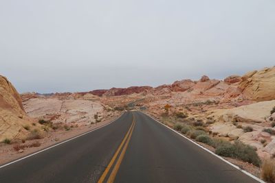 Road leading through multi colored hills in the desert