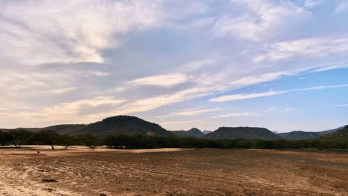 Scenic view of land and mountains against sky