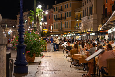 People in piazza bra at restaurants and cafes next to the arena di verona - italy