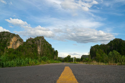 Road amidst trees against sky