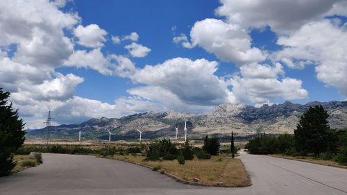 Road by trees against sky