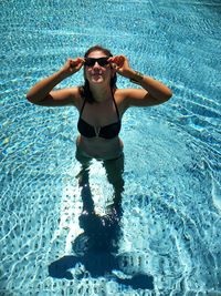 Full length of woman wearing sunglasses in swimming pool