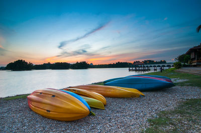 Boats in calm sea at sunset