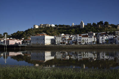 Houses in town against clear blue sky