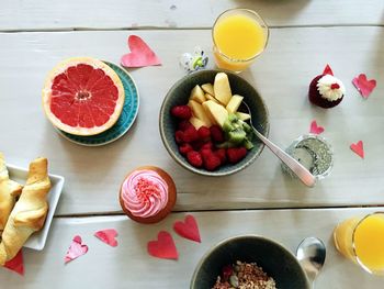 High angle view of fruit salad with dessert and juice served on table