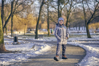 Full length portrait of boy standing in snow