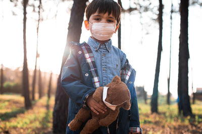 Portrait of boy with toy standing on field