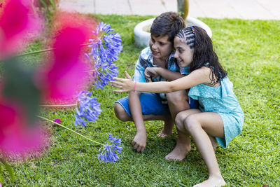 Two kids looking flowers on a garden