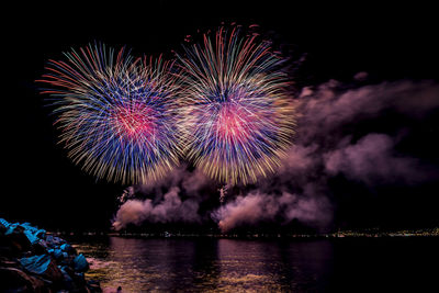 Firework display over river at night