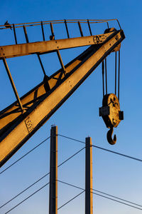 Low angle view of telephone pole against clear blue sky